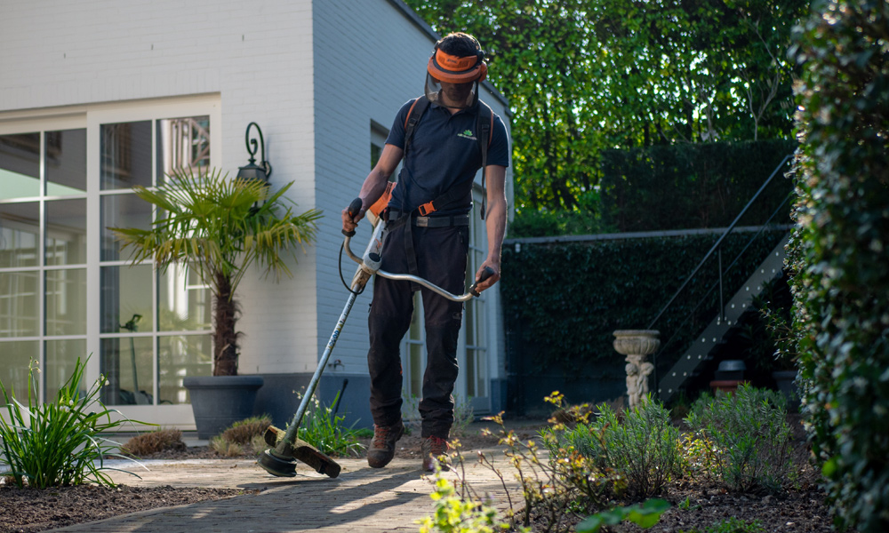 A workman using a string trimmer