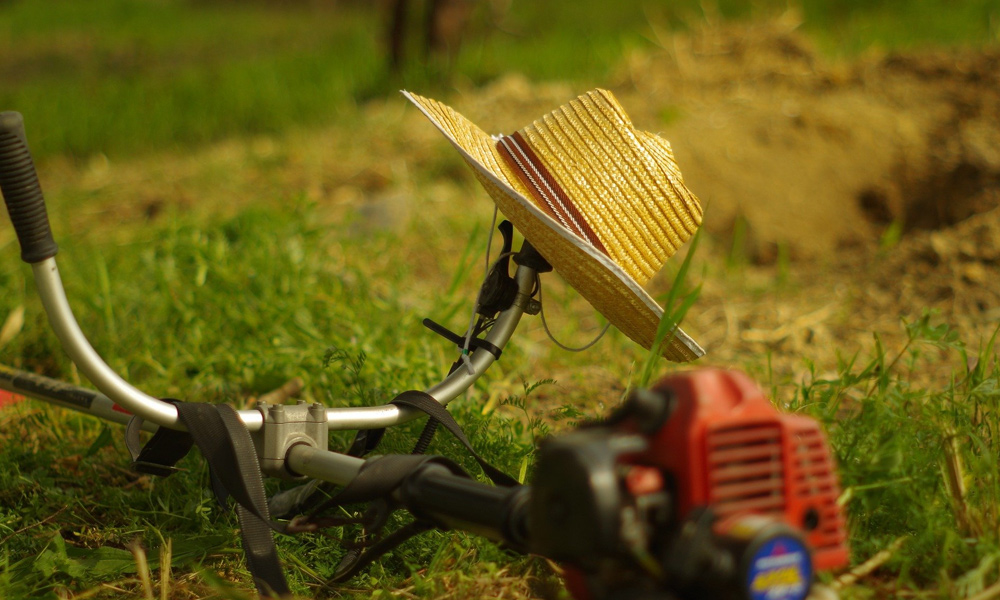 A hat resting on a string trimmer