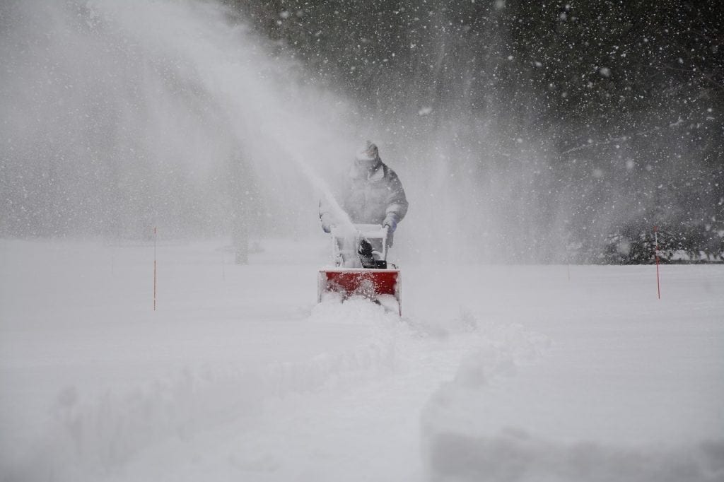 A man using a Snow Blower in heavy snow