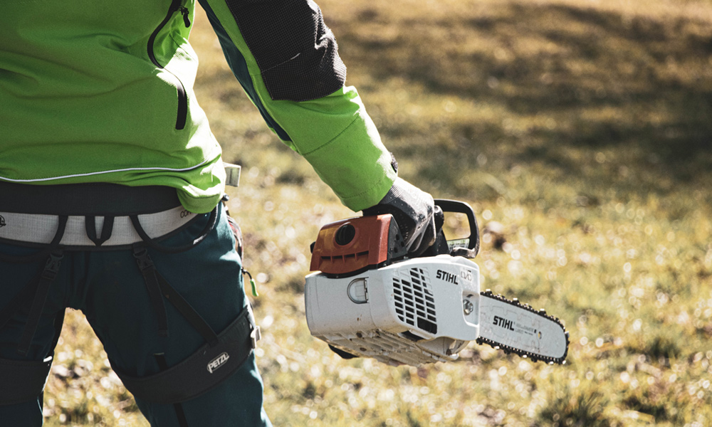 a work person holding a stihl chainsaw