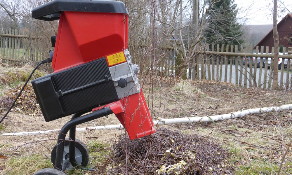 A chipper in a garden with Shredding sticks on the floor