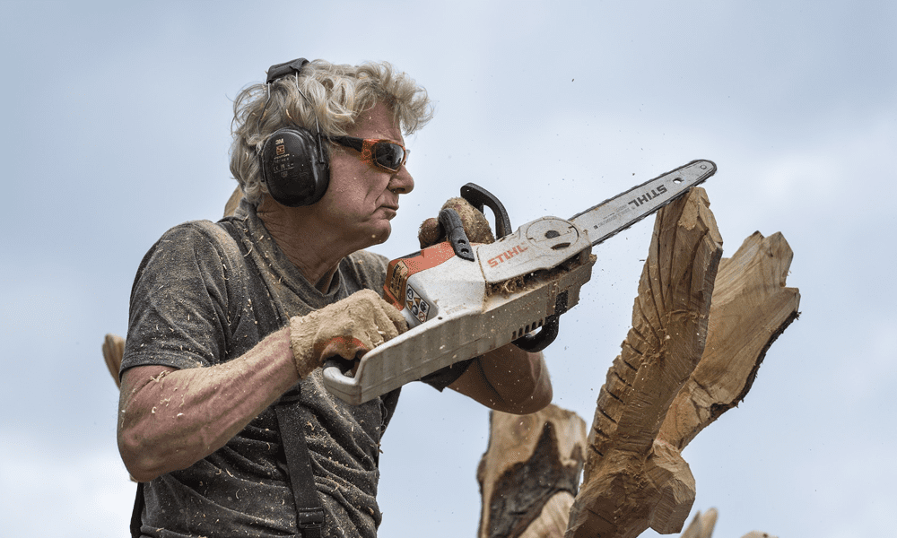 A man sculpting with a chainsaw