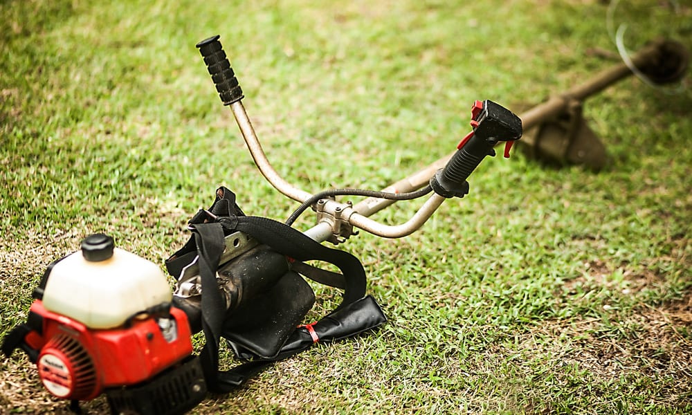 brush cutter laying on a lawn