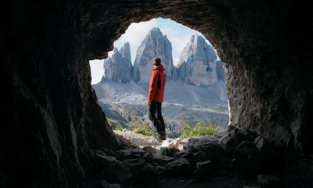 a guy looking at canyons under a cave