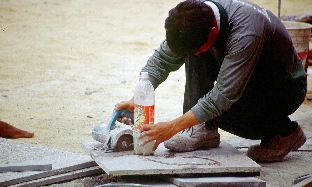 A workman using a tile cutter