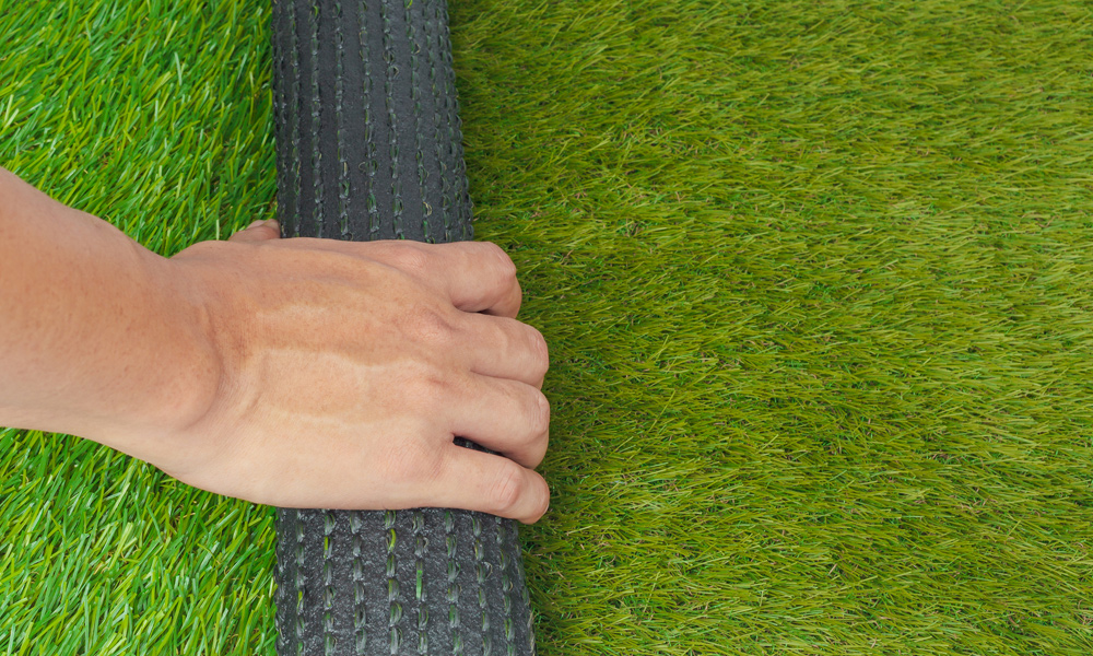 someone rolling artificial grass out