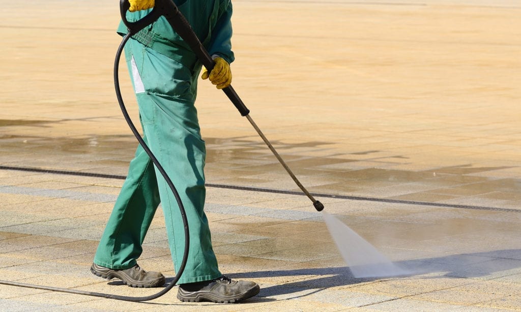 a work person using a jet wash