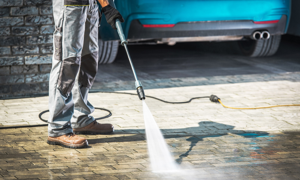 pressure washer cleaning a driveway