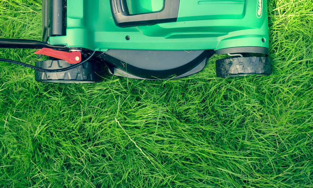 green lawn mower sitting on grass