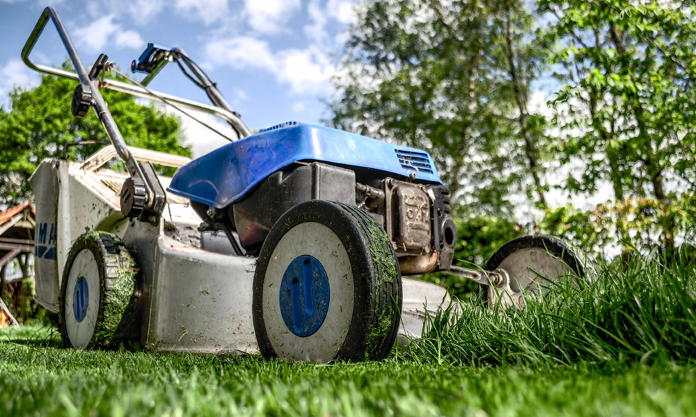 close up of a blue and silver gas lawn mower