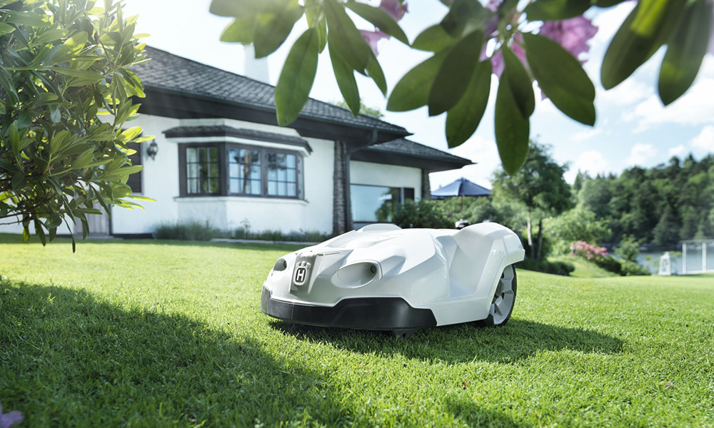 White Robotic Lawn Mower on a green grass