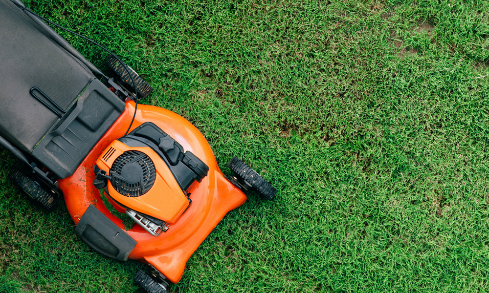 Orange and black lawn mower on grass
