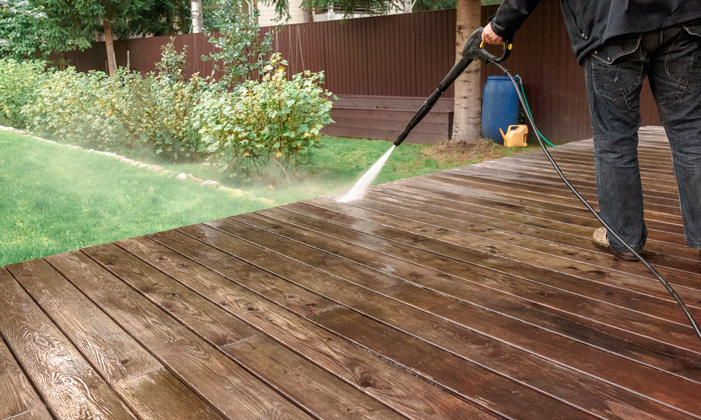 pressure washer cleaning a deck