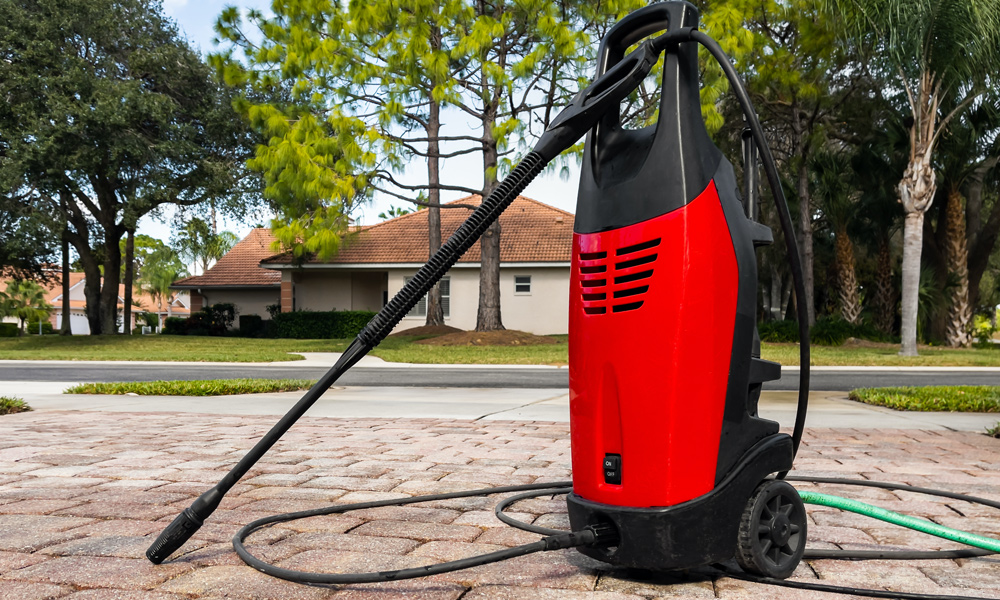 Red pressure washer sitting on a driveway